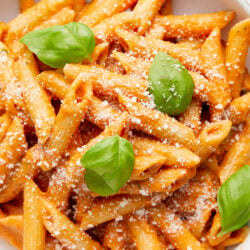 Penne pasta with creamy vodka sauce, topped with grated Parmesan cheese and fresh basil.