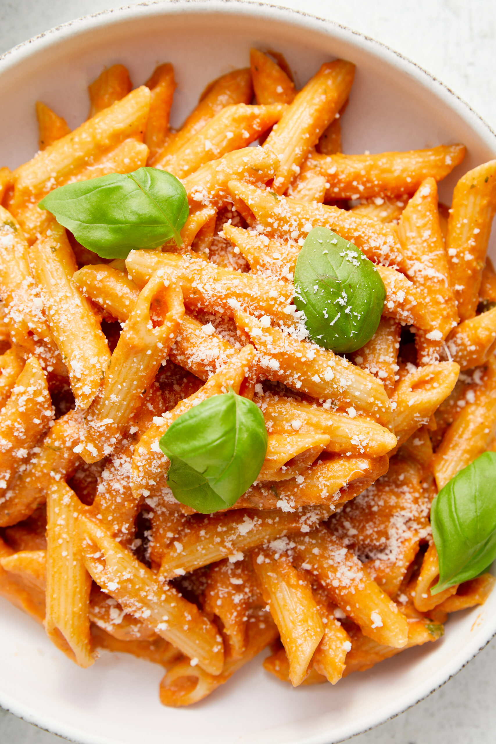 Penne pasta with creamy vodka sauce, topped with grated Parmesan cheese and fresh basil.