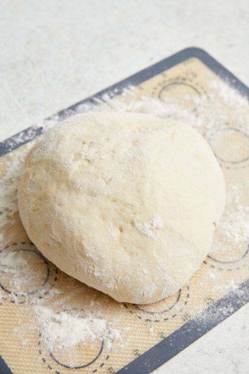 Shaping Air-Fryer Bread dough into a smooth ball on a lightly floured surface.