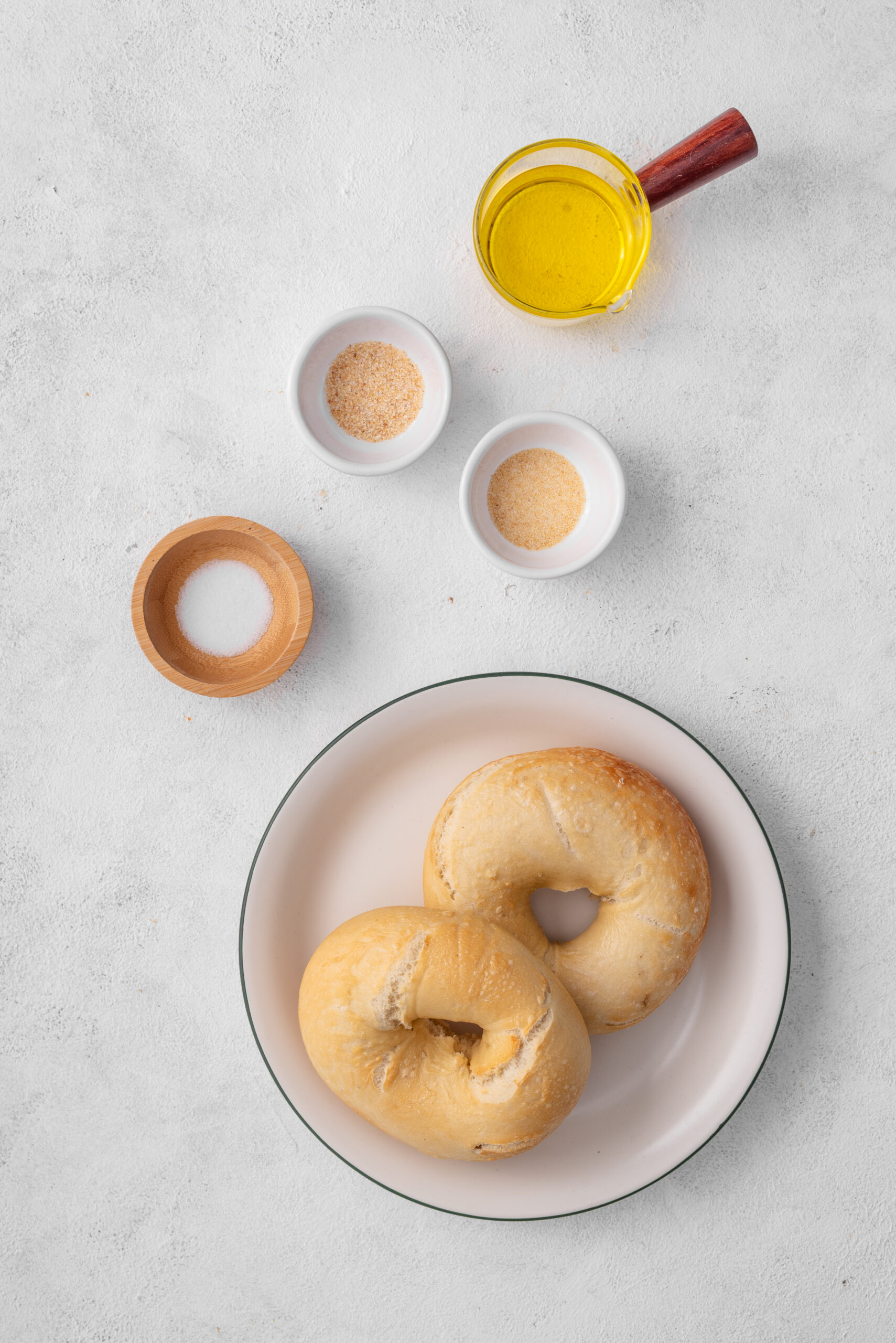 Ingredients for bagel chips: plain bagels, olive oil, salt, garlic powder, and onion powder.