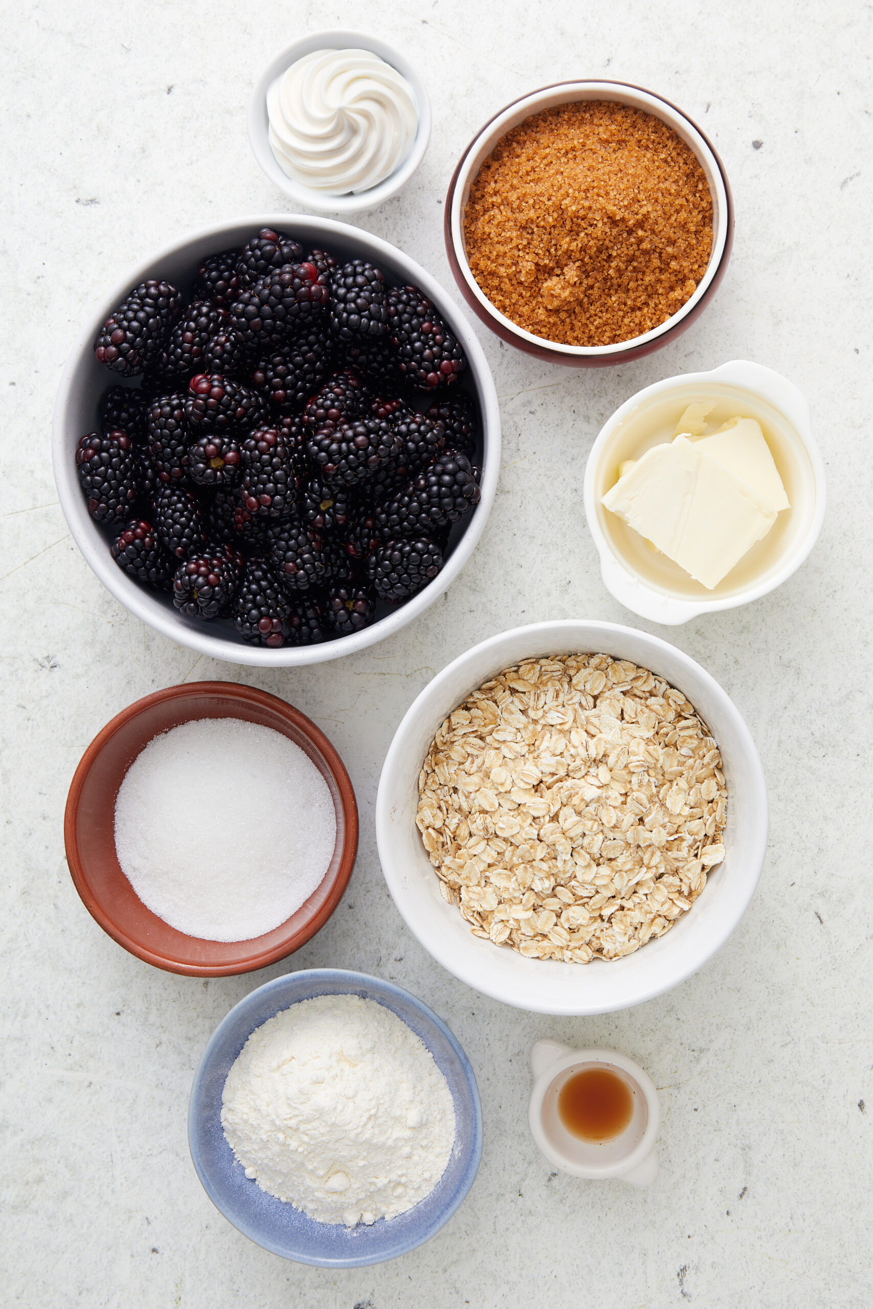 Ingredients for Blackberry Crisp: fresh blackberries, rolled oats, brown sugar, granulated sugar, all-purpose flour, butter, vanilla extract, and whipped cream.