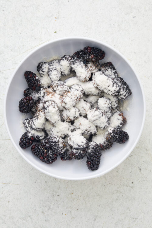 Tossing fresh blackberries with sugar and flour for Blackberry Crisp.