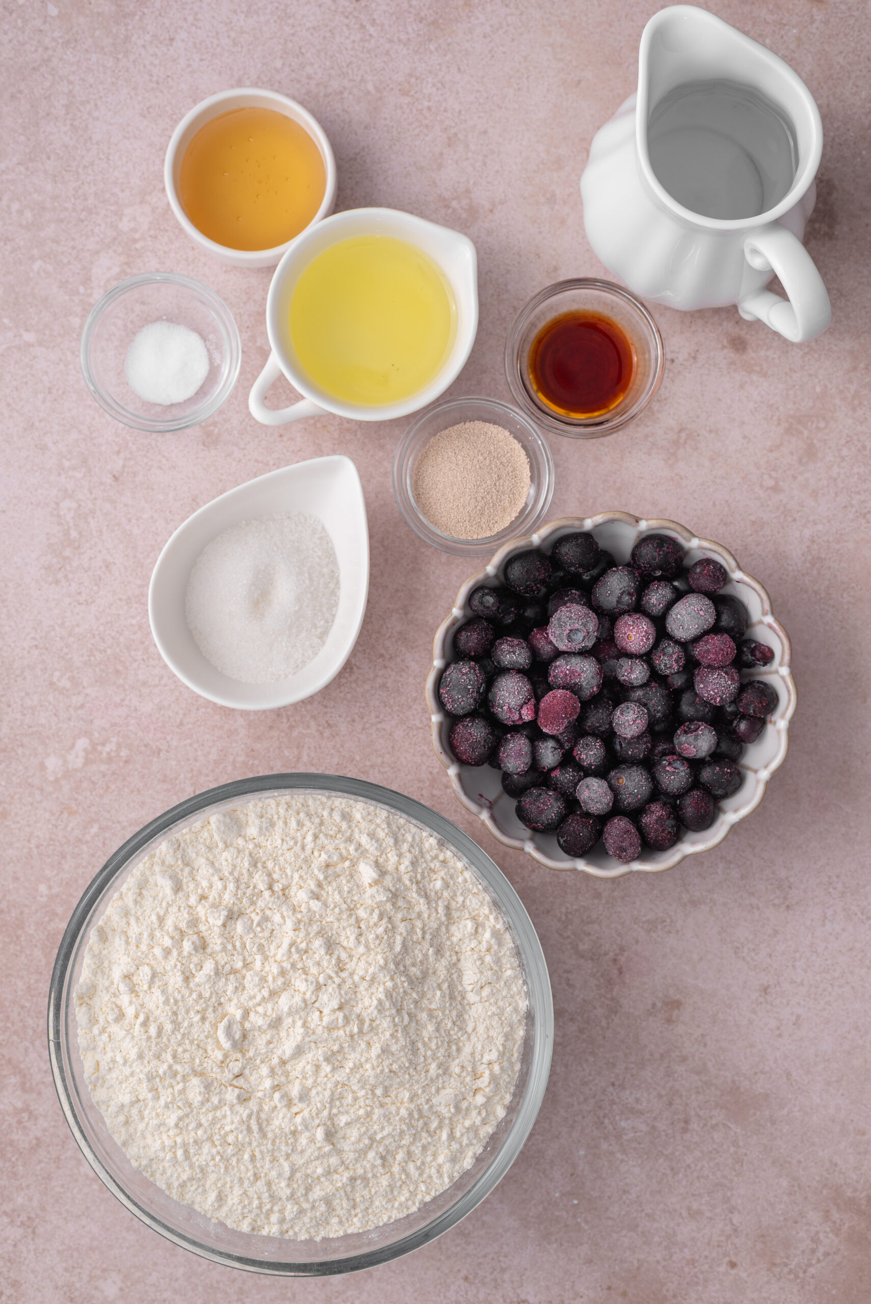 Ingredients for Blueberry Bagels: bread flour, frozen blueberries, honey, egg white, salt, granulated sugar, active dry yeast, vanilla extract.
