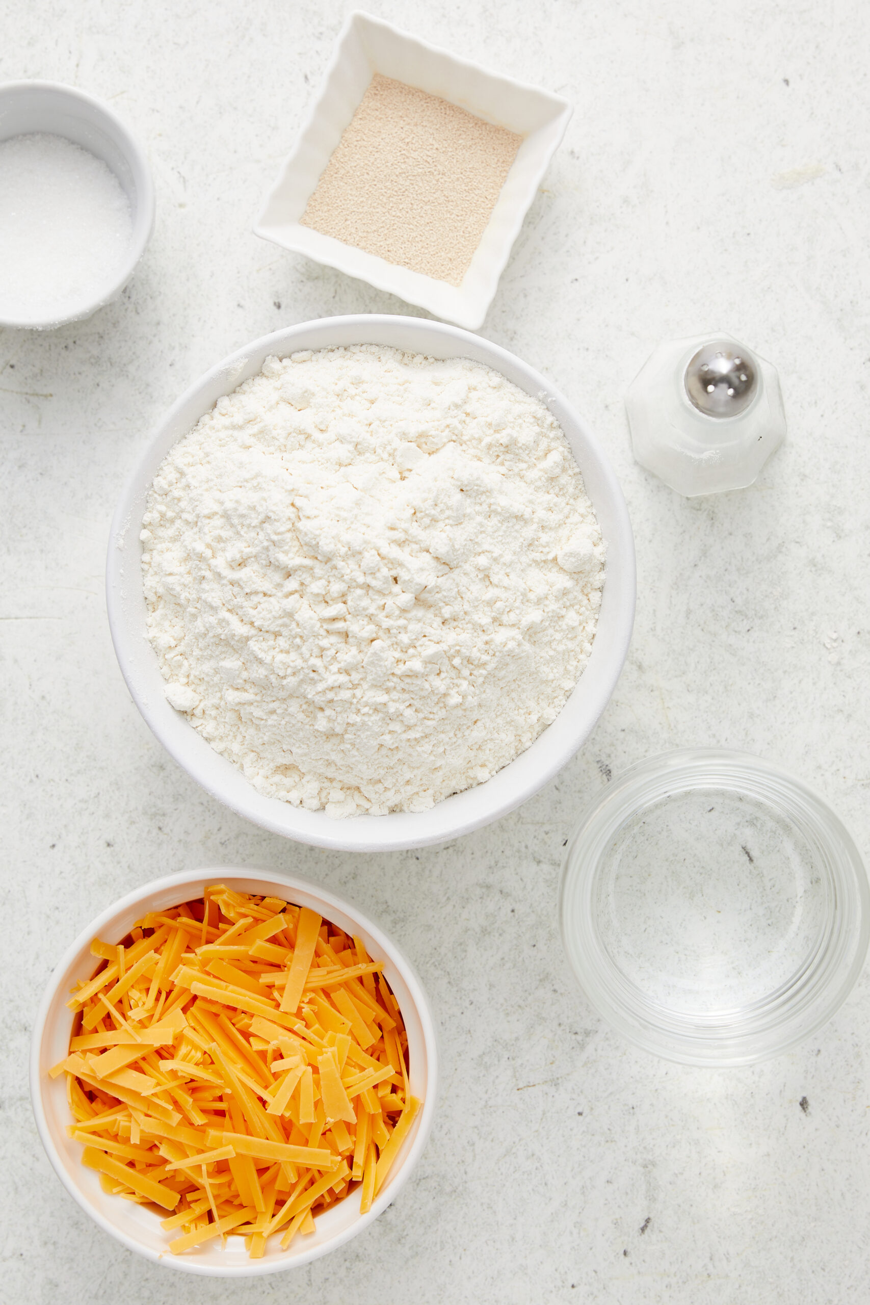Ingredients for Cheese Bread: bread flour, instant yeast, granulated sugar, salt, water, and shredded cheddar cheese.