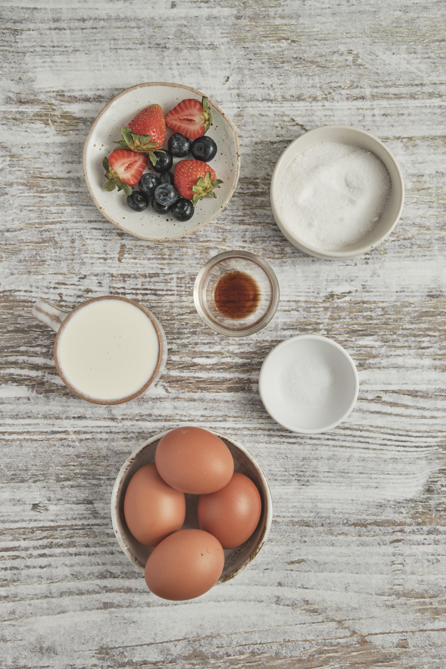 Ingredients for Cr&egrave;me Br&ucirc;l&eacute;e: heavy cream, vanilla bean paste, eggs, granulated sugar, fresh berries.
