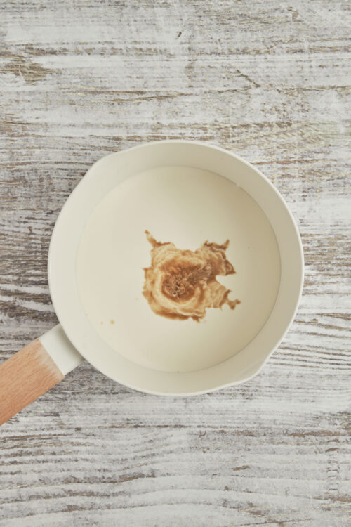 Heating heavy cream and vanilla bean paste for cr&egrave;me br&ucirc;l&eacute;e.