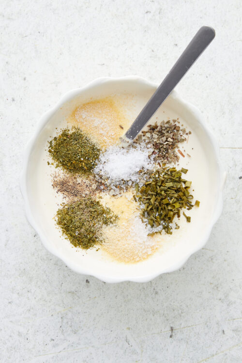 Spices and herbs for homemade ranch dressing in a bowl.