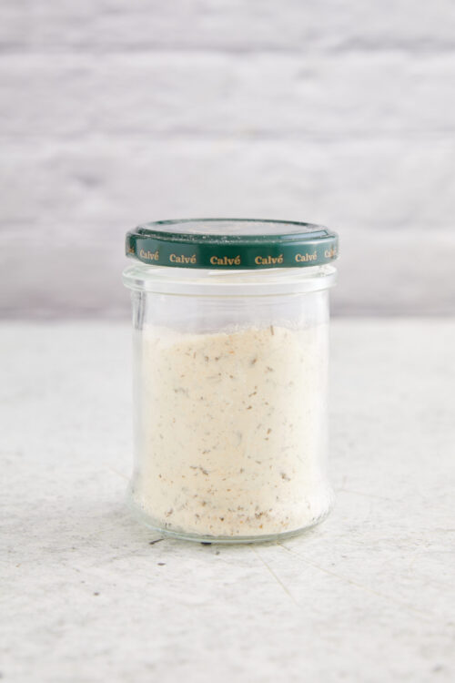 Homemade ranch seasoning in a glass jar with a green lid.
