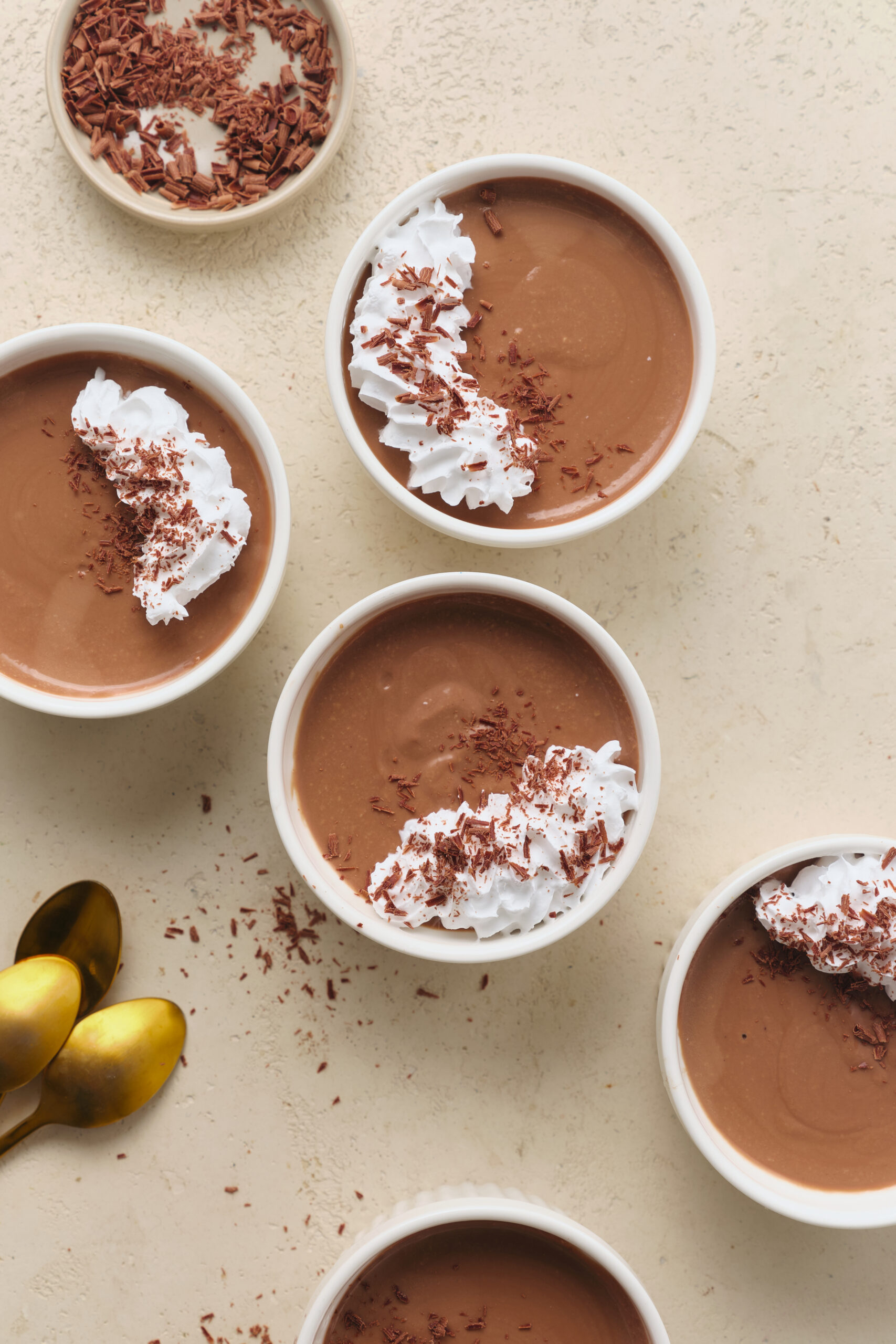 Pot de cr&egrave;me served in white ramekins, topped with whipped cream and chocolate shavings.