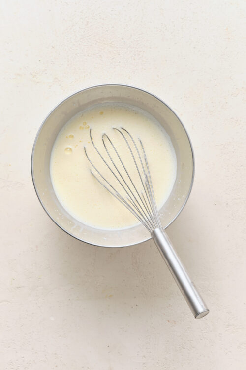Whisking egg yolks and half-and-half in a metal bowl for Pot De Cr&egrave;me.