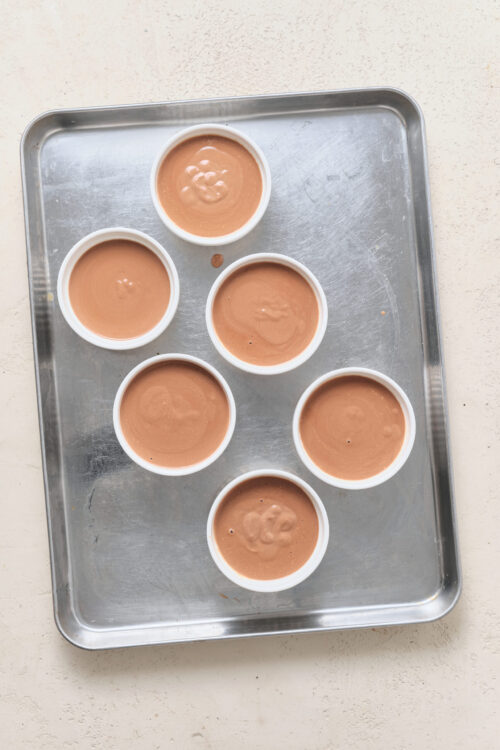 Six ramekins filled with smooth chocolate Pot De Cr&egrave;me custard.