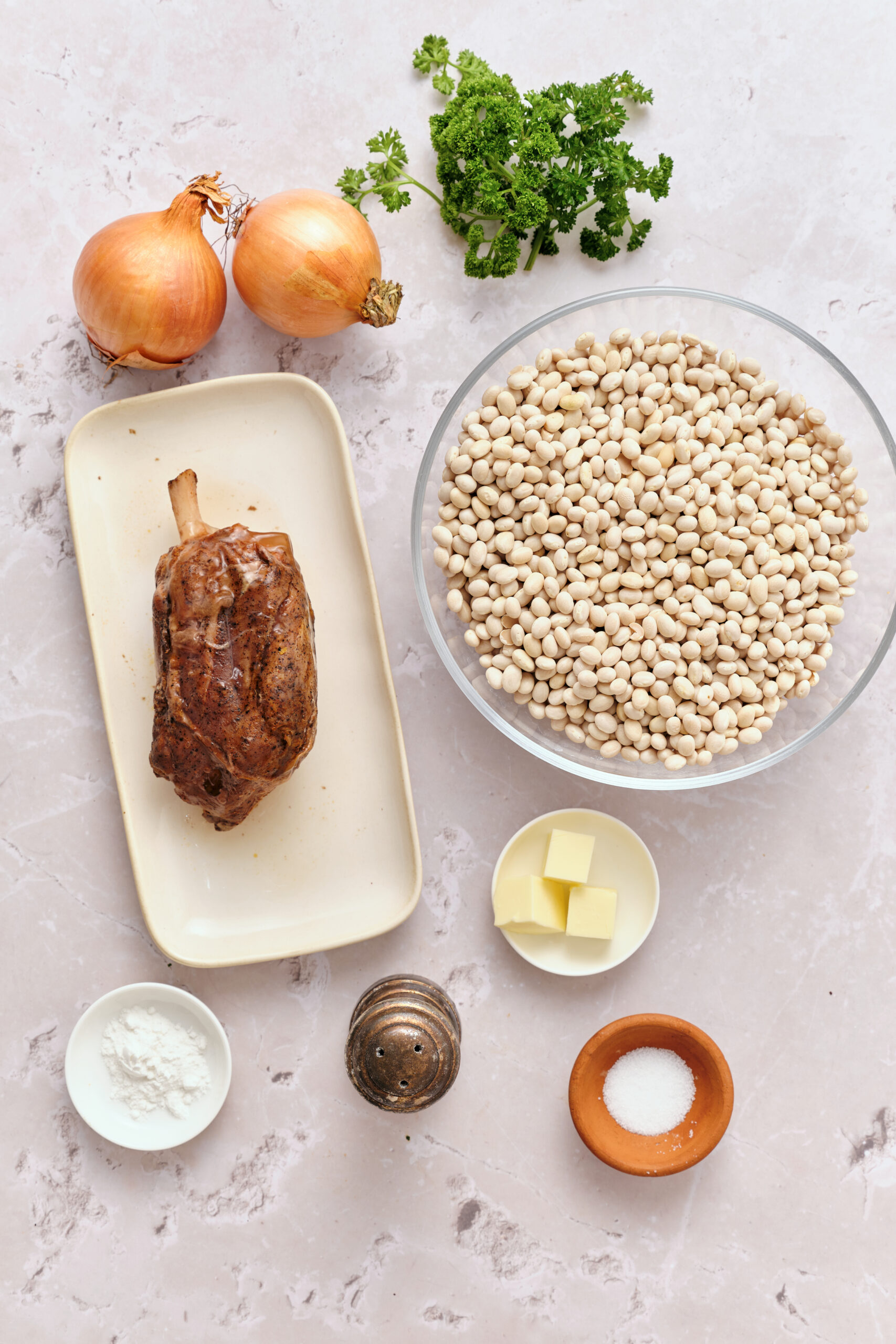 Ingredients for Senate Bean Soup Recipe: dry navy beans, smoked ham hock, yellow onions, fresh parsley, butter, salt, and baking soda.