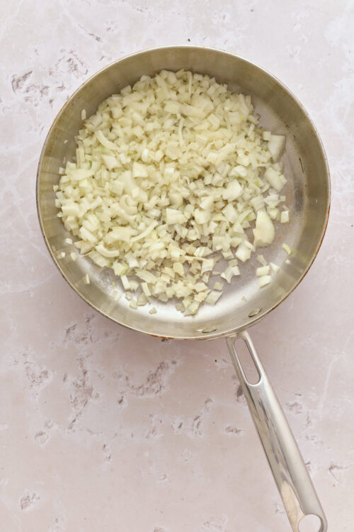 Saut&eacute;ing diced yellow onions in a skillet for Senate Bean Soup.