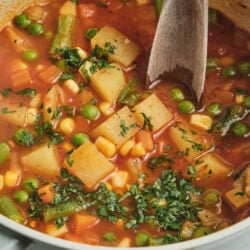 Vegetable soup with potatoes, peas, corn, green beans, and fresh parsley.