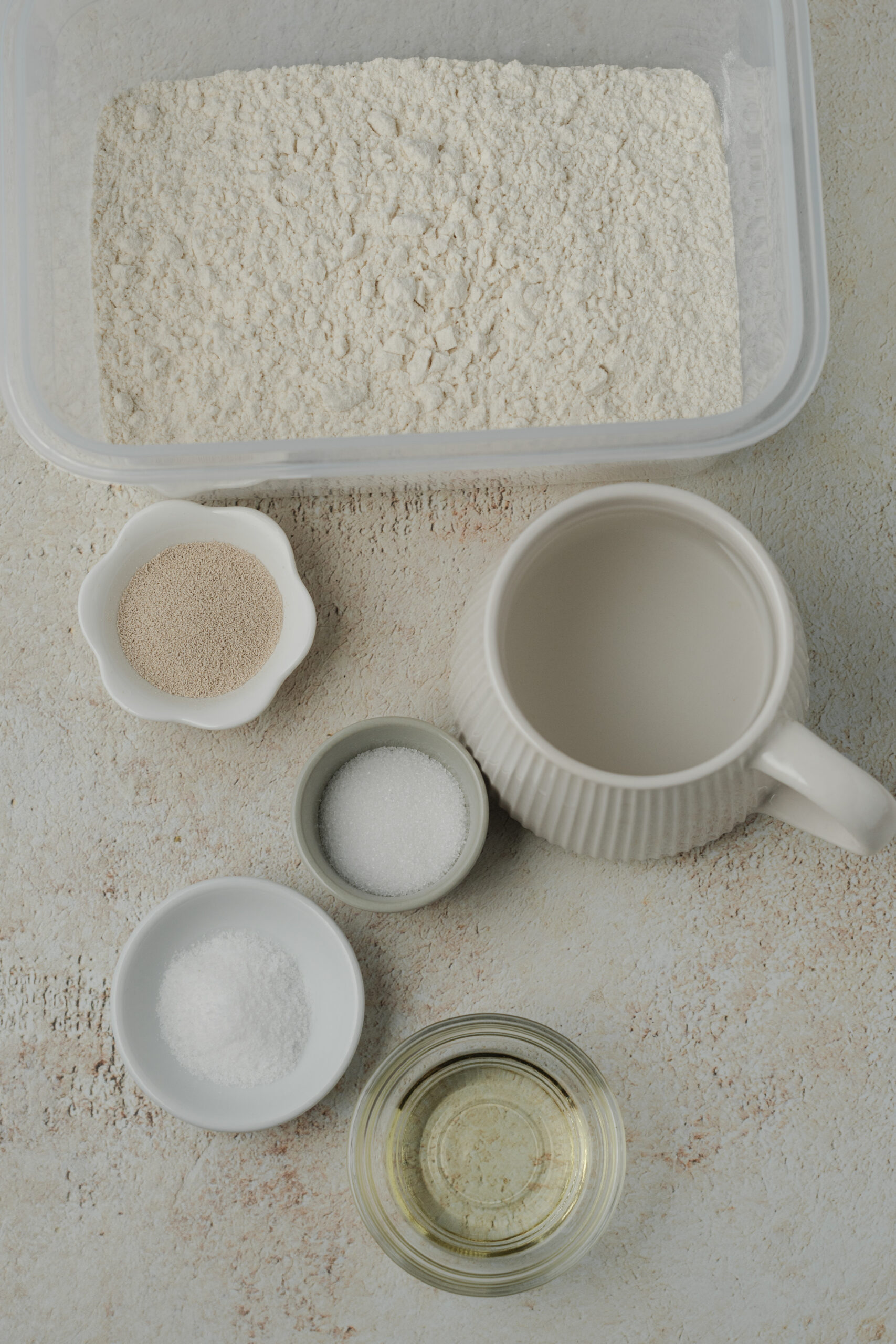 Ingredients for Artisan Bread Recipe: bread flour, instant yeast, granulated sugar, salt, olive oil, and warm water.