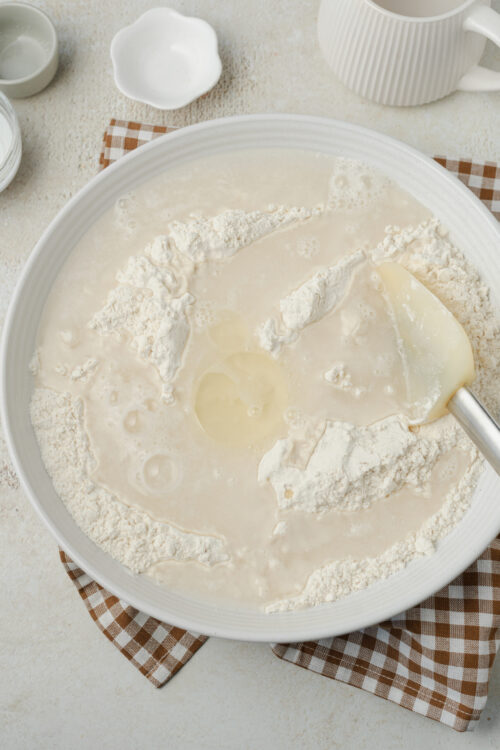 Stirring flour, oil, and warm water for artisan bread dough.