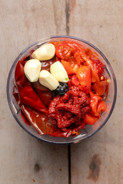 Combining ingredients for Homemade Harissa in a food processor.
