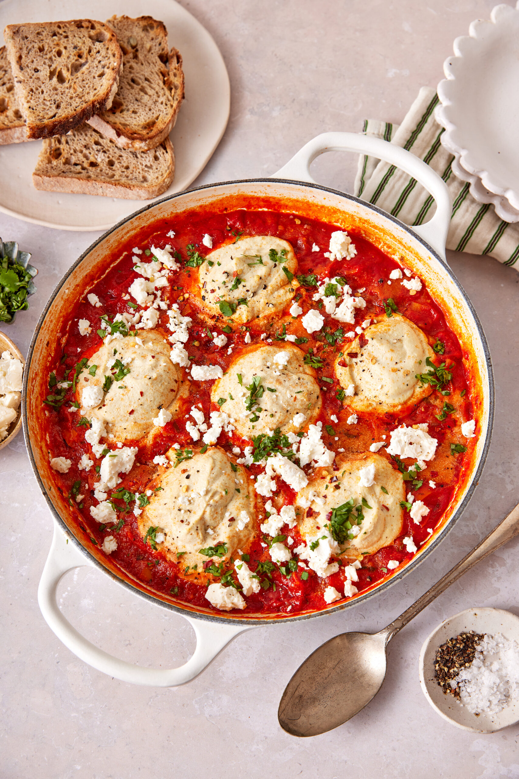 Vegan shakshuka in a white skillet with tofu, tomato sauce, and vegan feta.