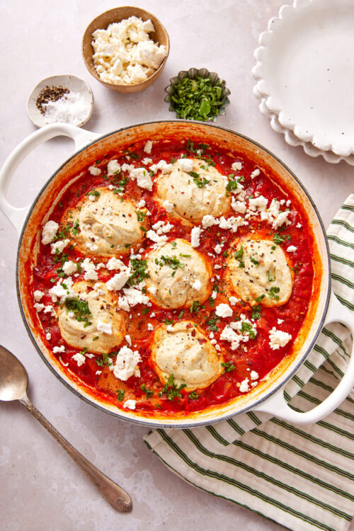 Vegan shakshuka in a skillet, topped with vegan feta and cilantro.