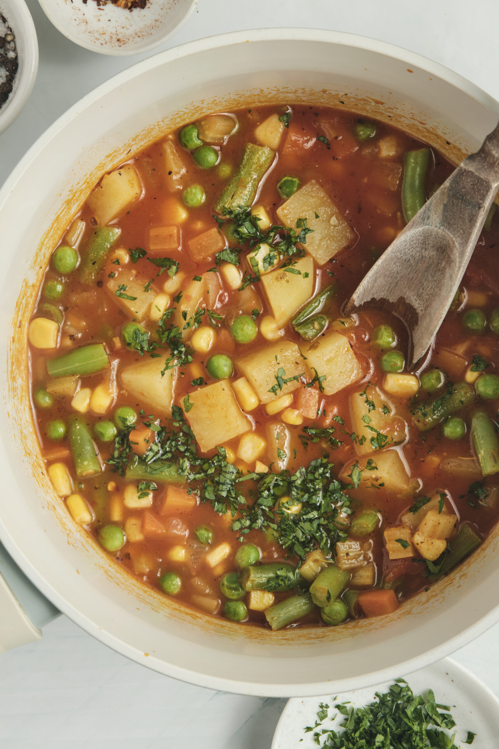 Vegetable Soup Recipe with potatoes, carrots, peas, corn, green beans, and fresh parsley.